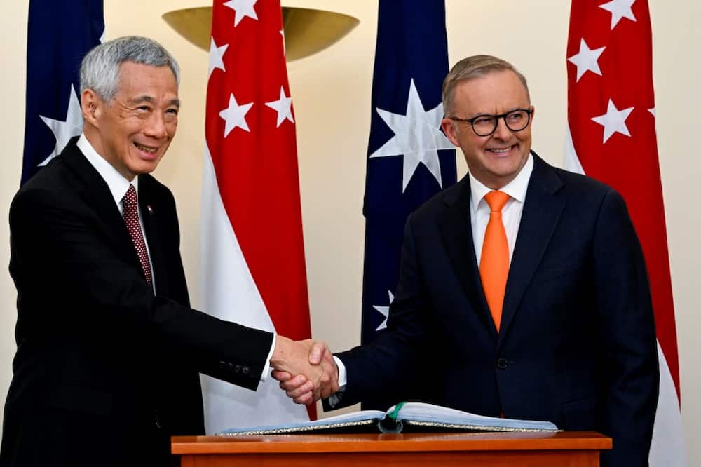 Australia's Prime Minister Anthony Albanese (R) shakes hands with Singapore's Prime Minister Lee Hsien Loong during their meeting at Parliament House in Canberra on October 18, 2022.