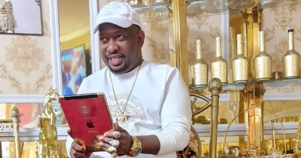 Mike Sonko holding a phone.