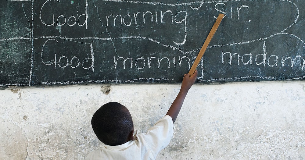 A child writing on the blackboard in a Tanzanian school.