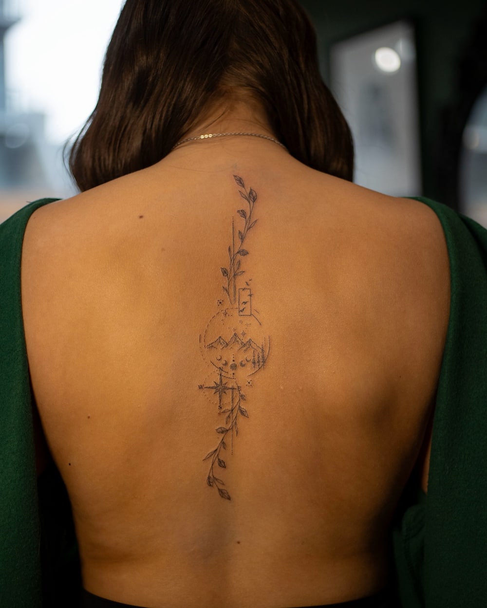 Back view of woman with intricate vine tattoo.