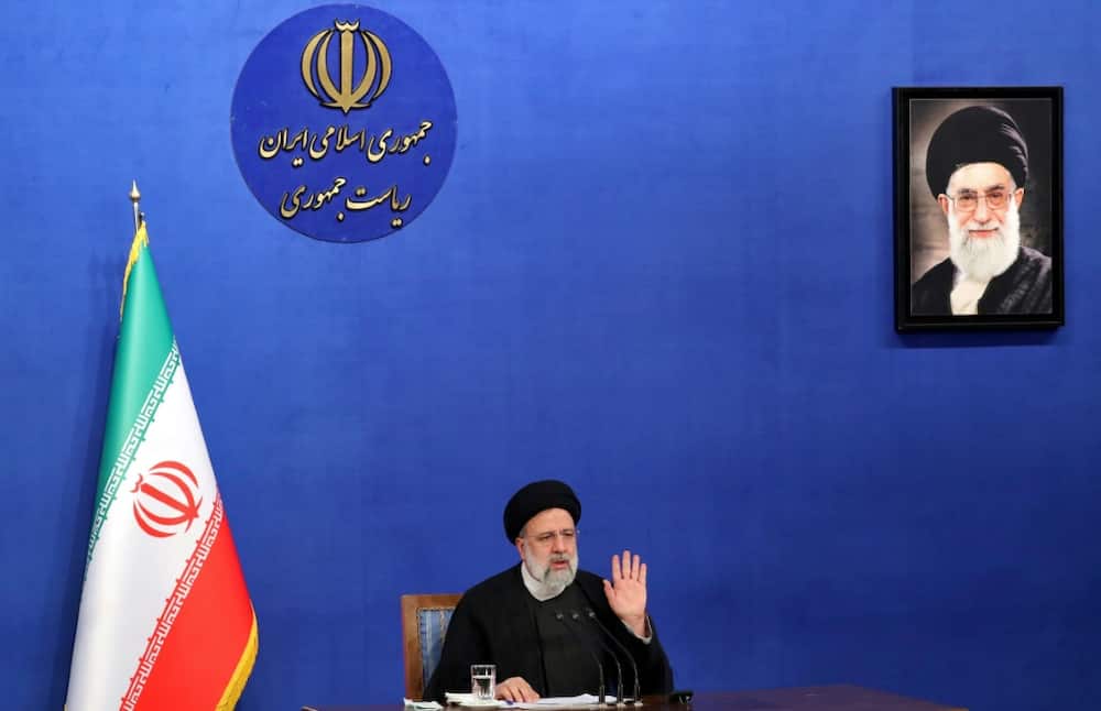 Iranian President Ebrahim Raisi sits near a portrait of Iran's Supreme Leader Ayatollah Ali Khamenei as he speaks during a press conference in Tehran on August 29, 2022
