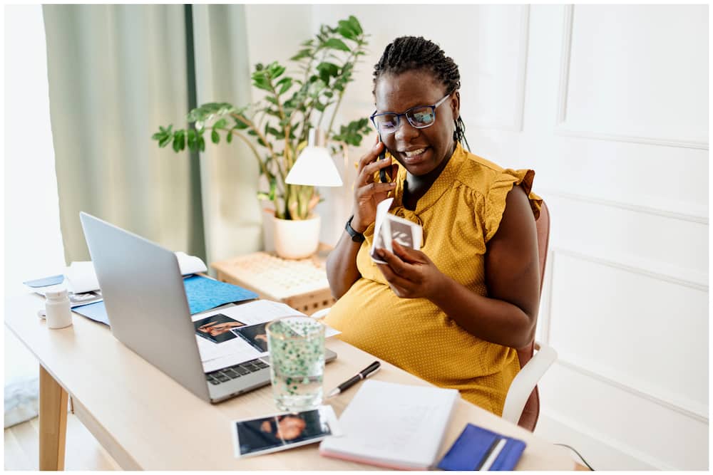 A black pregnant woman working in the office