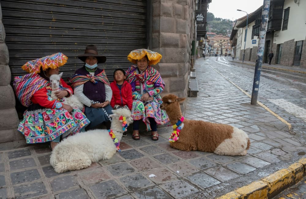 Indigenous women in Cusco wait in the street for the arrival of tourists in the hope of being able to make some money