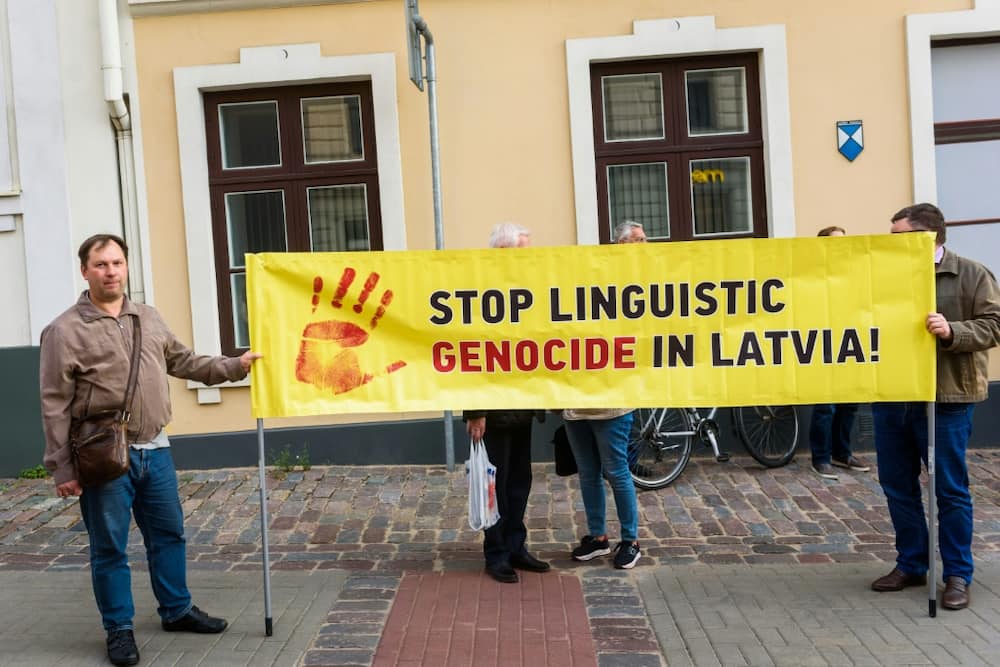 People hold a banner to protest language reforms which Latvia's Russian-speaking miniroty say are increasing their cultural marginalisation