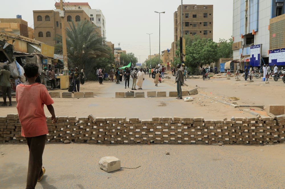 Sudanese anti-coup protesters gather on a blockaded street during a sit-in outside al-Jawda hospital in the capital Khartoum
