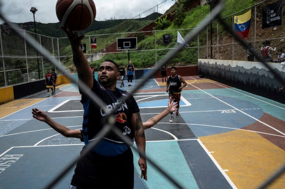 Members of local youth teams supported by NGO Caracas Mi Convive, which seeks to keep young people away from violence, play a basketball game at Santa Eduviges neighbourhood in Caracas in August, 2022