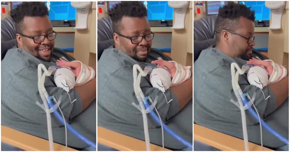 Father sings to premature son, raises hand in acknowledgement.