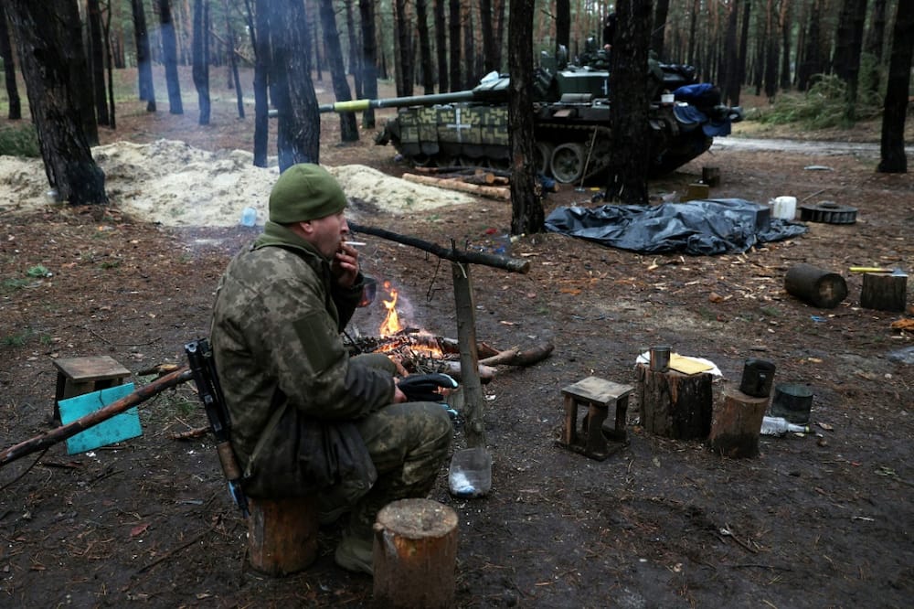 A Ukrainian serviceman smokes a cigarette in a forest near the front line in the Kharkiv region