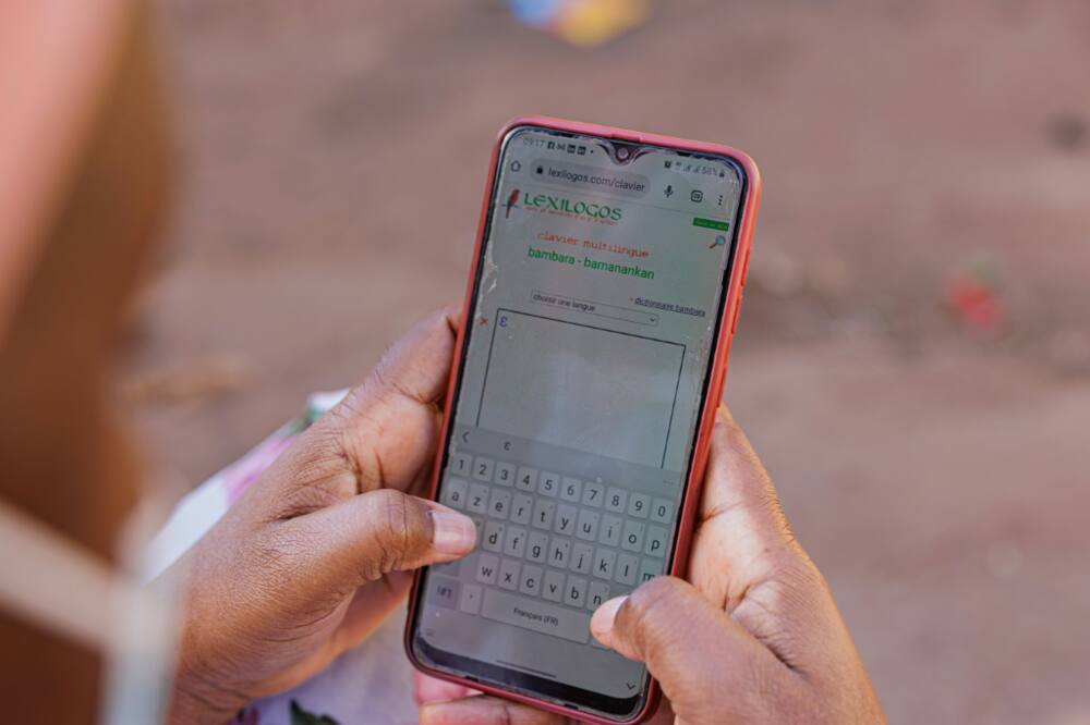 Tech support: A woman uses a dictionary app to help her type a message in Bambara on her smartphone