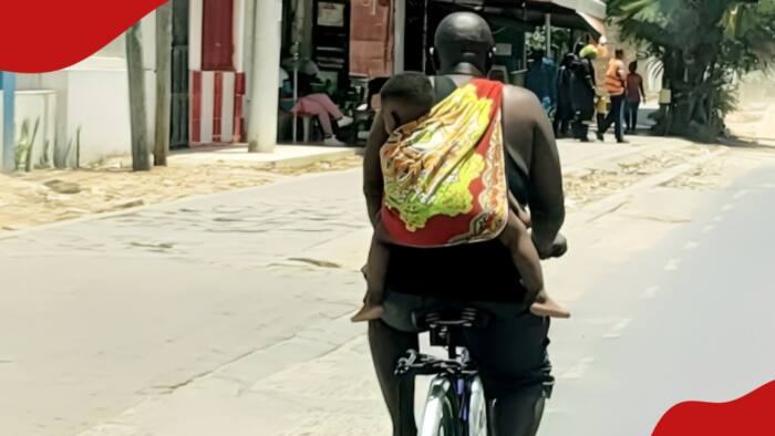 Photo of Mombasa Father Riding Bicycle With Baby On His Back Lights Up Internet