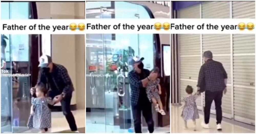Father carries daughter next to the supermarket.