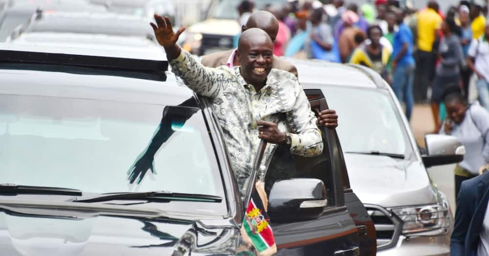 Rigathi Gachagua waves through his car's door in Kisumu.