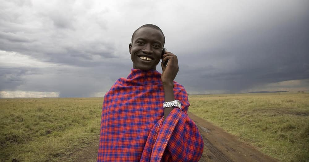 A man happily uses his phone to communicate.