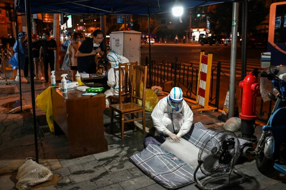 Health workers in Shanghai have been sitting or lying on blocks of ice to cool down as they carried out a mass testing drive