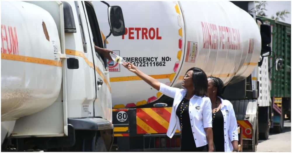 Ladies handing water to truck driver.