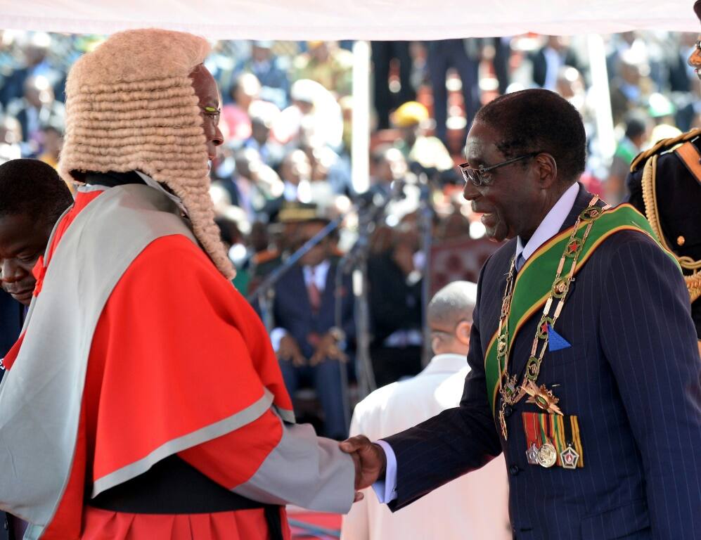 Britain's relations with Zimbabwe went downhill after Mugabe, seen here at a post-election inauguration ceremony in 2013, cracked down on dissent and seized land from white farmers