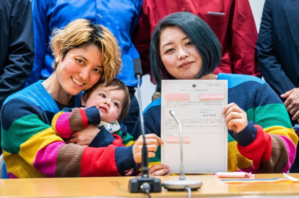 Mamiko Moda (L) and her partner Satoko Nagamura, along with their son, hold a same-sex partnership certificate at a Tuesday press conference