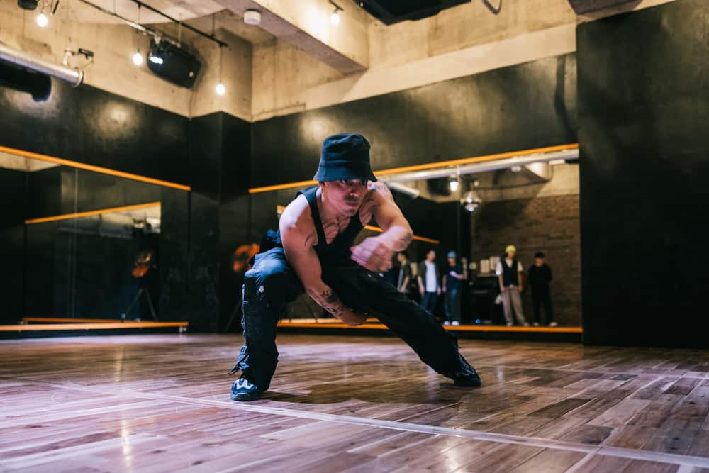 Young man performing and practising hip hop dance moves in a indoor dance studio.