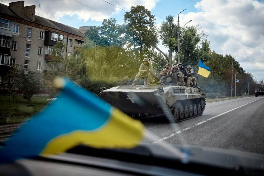 This picture released by Ukraine's Presidential press office shows Ukrainian soldiers on a tank in a street of Kupiansk