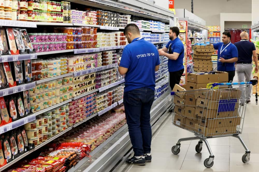 Employees of the Carrefour Hypermarket in Raanana, Israel, stock shelves before the French firm's opening in the country