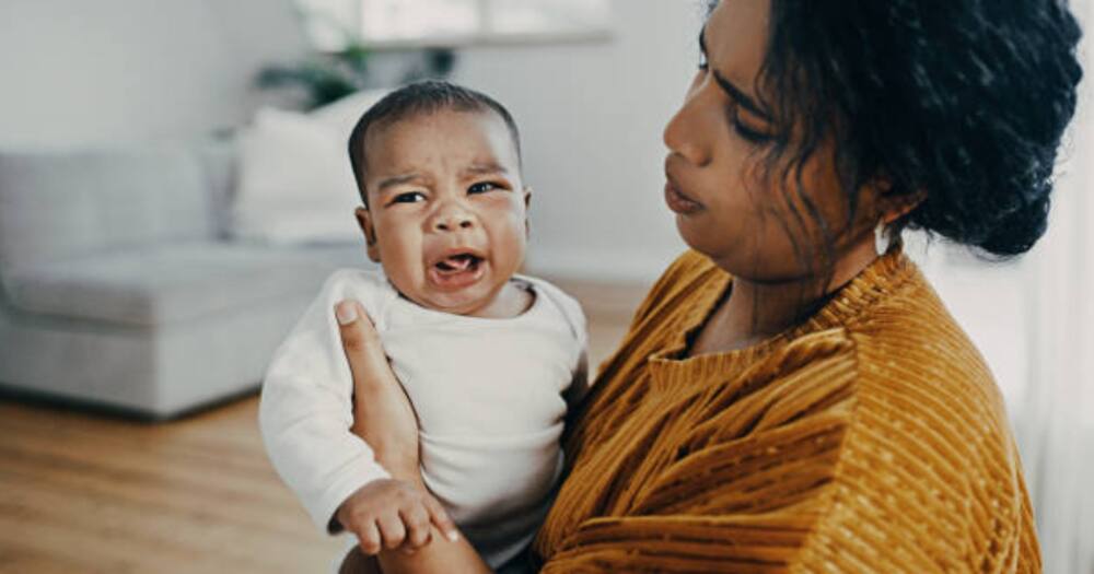 Woman holding a crying baby.