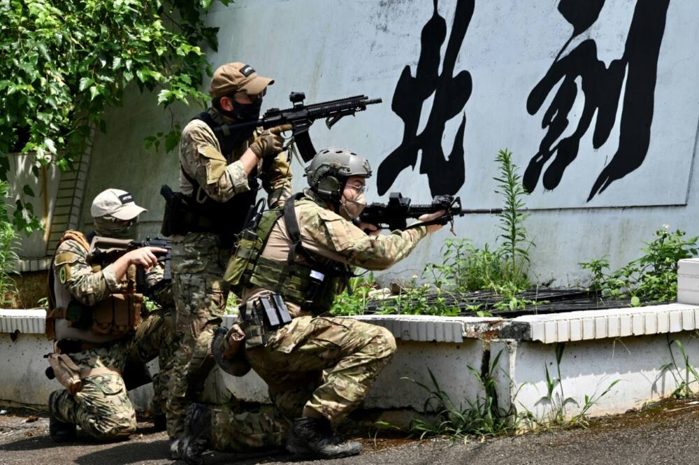 Taiwanese civilians in tactical gear and replica weapons take part in an urban warfare workshop in New Taipei City