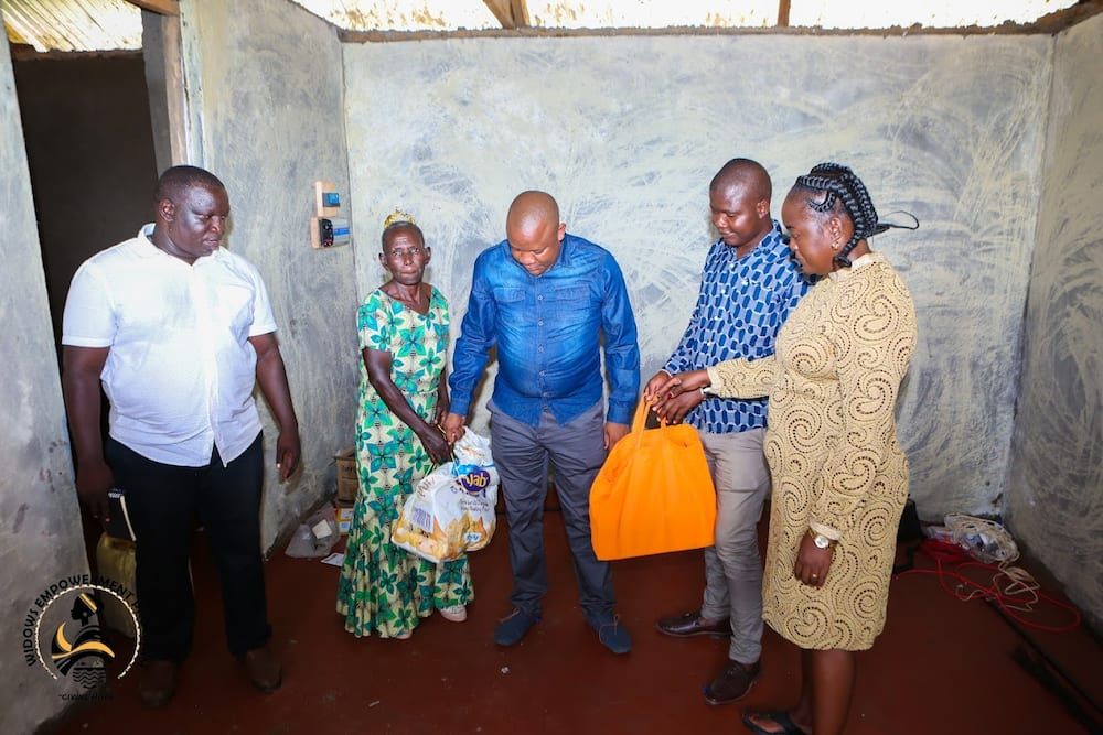Siaya widow (second from left) receives shopping from Widows Empowerment Programme team.