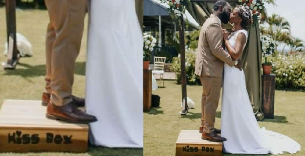 Groom stands on a platform to kiss taller bride.