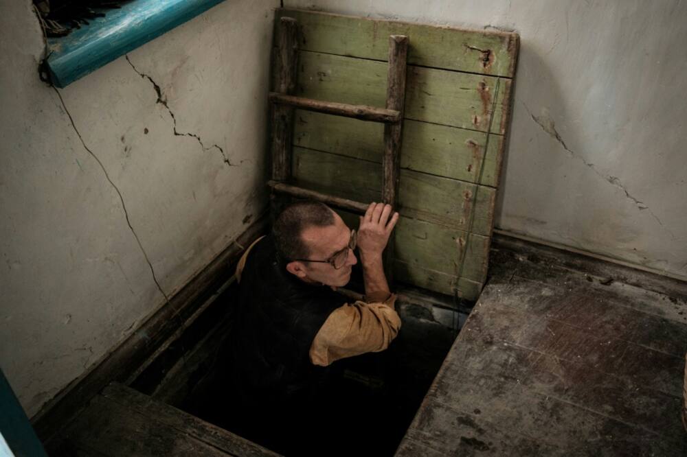 Ivan Lobachov emerges from a cellar used as a shelter, in the family house which was partially destroyed by shelling