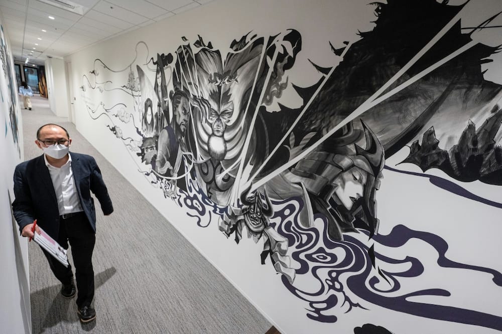 A Netflix employee walks past an anime mural at the company's Tokyo offices