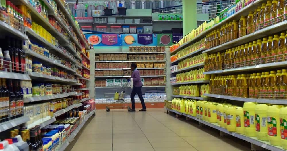 A person shopping along the supermarket aisle.