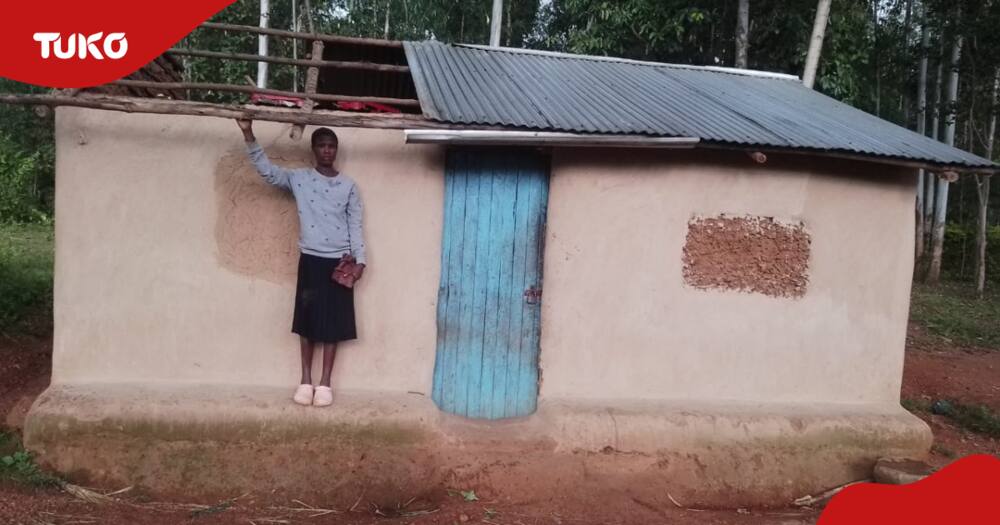 A woma stands outside an unroofed house in Homa Bay.