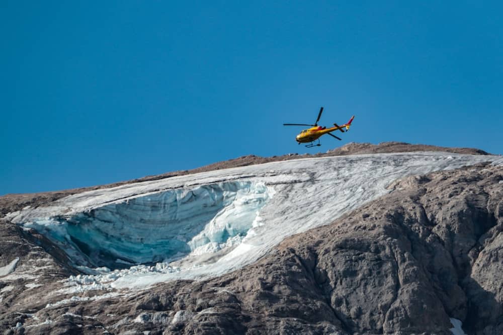 A rescue helicopter flies over the partially collapsed glacier on Marmolada, the highest mountain in the Dolomites