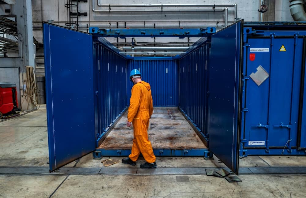 A worker cleans a container used to transport decontaminated radioactive material at the former Lubmin plant in Germany
