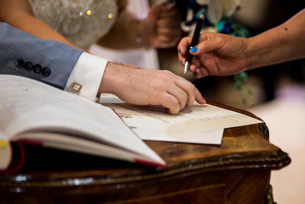 A person is signing a marriage certificate