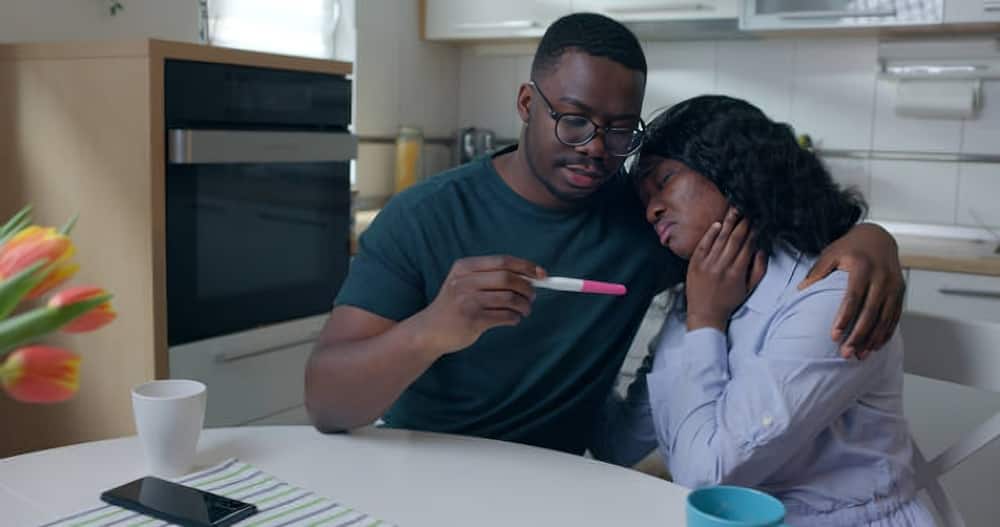 Photo of stressed young couple looking at the results of a pregnancy test.