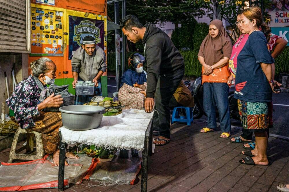 Customers queue in the early morning hours to snap up Mbah Satinem's supply of lupis cakes before they disappear