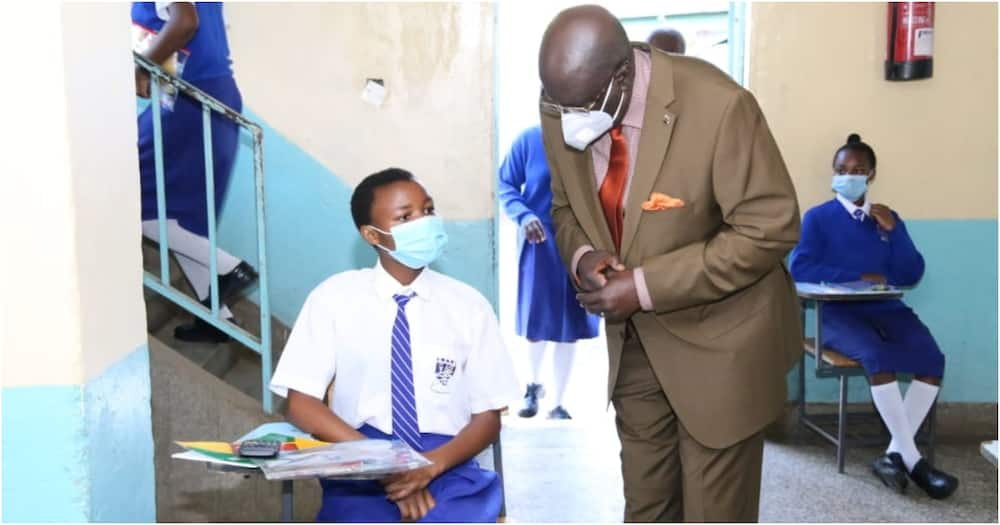 Education Cabinet Secretary George Magoha conversing with a KCSE candidate. Photo: EduMinKenya.