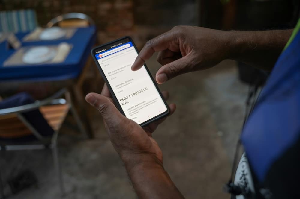 A worker shows a digital menu at Casa Nossa restaurant in the Lapa neighborhood in Rio de Janeiro, Brazil in May 2023.