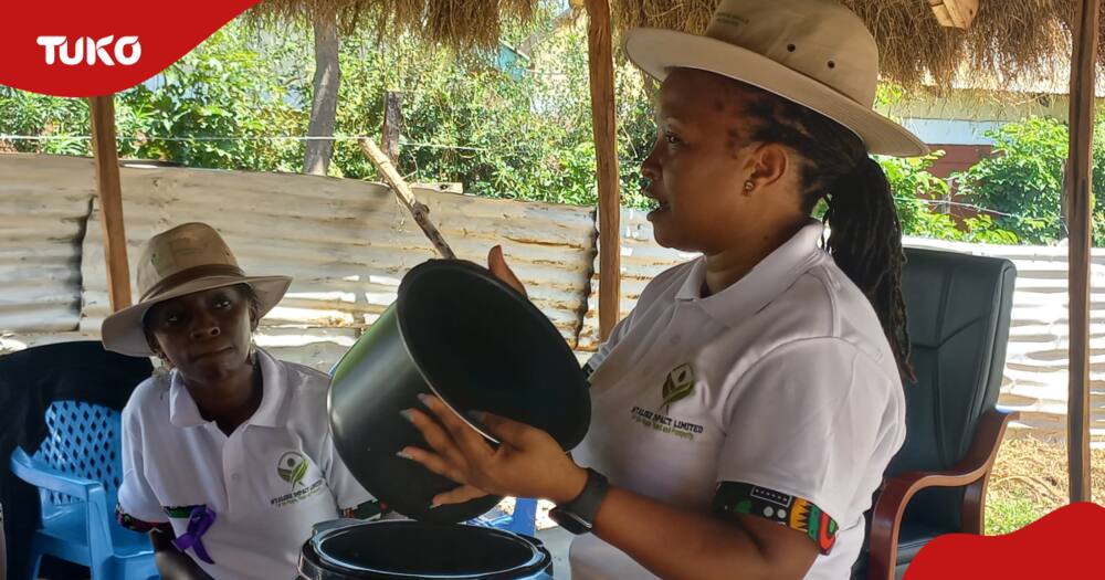 A woman demonstrating how an electric pressure cooker is used to her counterparts in Homa Bay