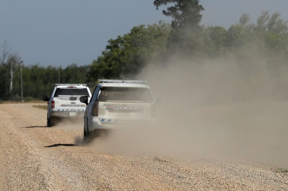 Police vehicles patrol James Smith Cree Nation reserve in Canada following a possible sighting of a fugitive suspected in the stabbings that occurred there and in the town of Weldon