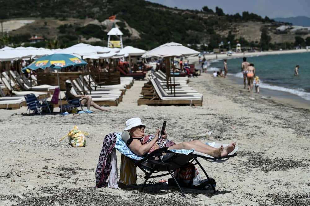 A woman enjoys the sun on a beach on Greece's Halkidiki peninsula