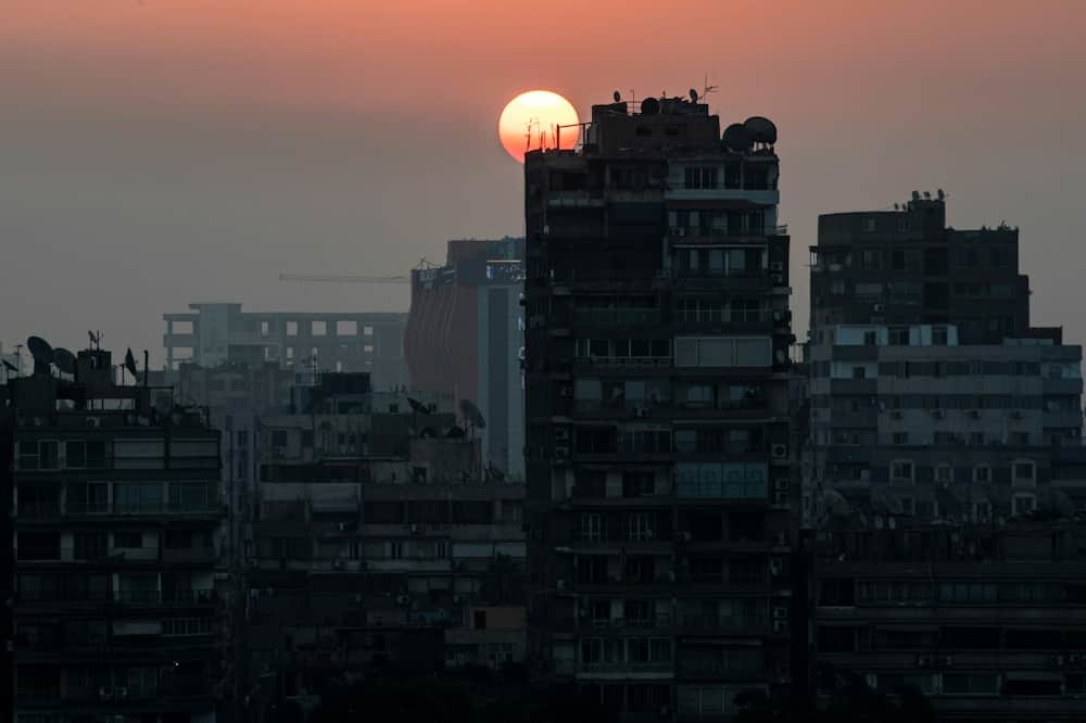 The sun rises behind the skyline of Egypt's capital Cairo and its Nile river island of Manial