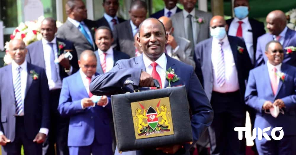 Treasury CS Ukur Yatani poses with a budget briefcase and MPs at parliament.