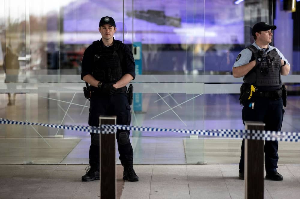 Police stand guard at the entrance of a terminal Canberra airport