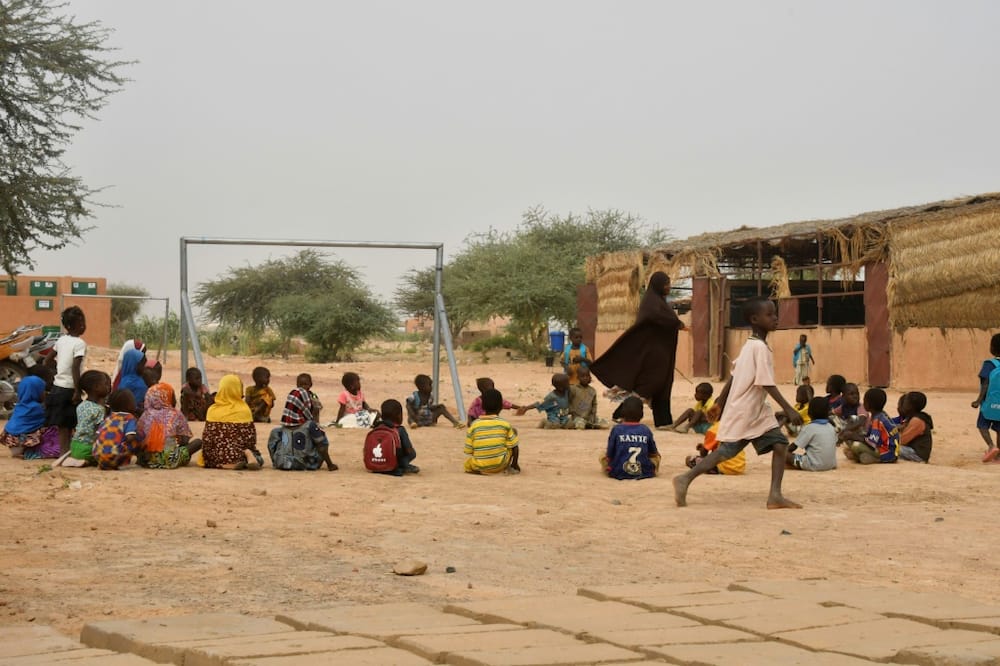 Time for play: A teacher and her pupils in the yard of a school set up for displaced children