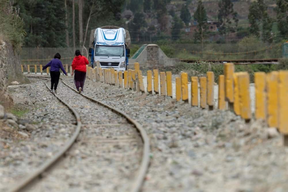 Two children run along the train tracks that serve the world famous Machu Picchu Inca citadel that has been closed over the social unrest in Peru