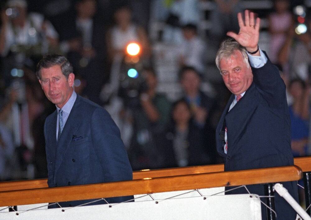Outgoing Hong Kong governor Chris Patten (R) waves to well-wishers as he boards the Royal Yacht Britannia with Prince Charles on July 1, 1997