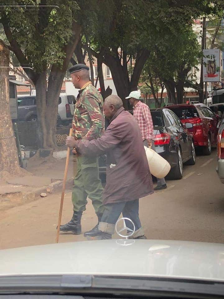 Photos of Nairobi police officer helping blind man cross road warms hearts online