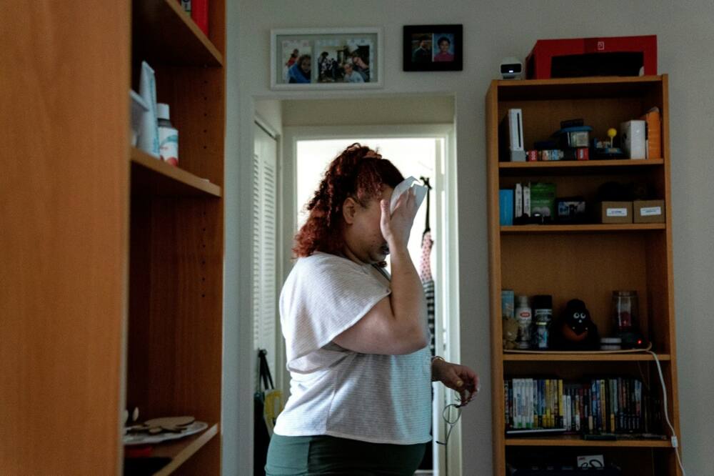 Laine Carolyn, shown here wiping her face during an interview at her Alexandria home, is among tenants in the United States confronting eviction risks in the face of high inflation